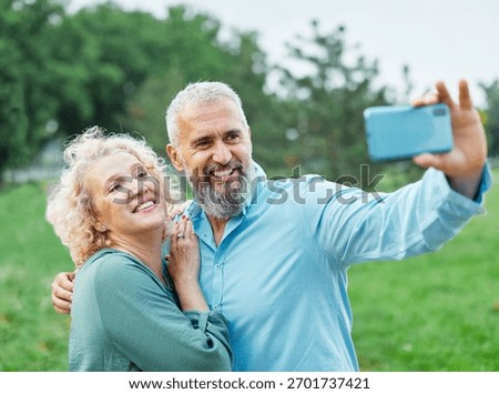 Happy active mid aged couple taking selfie in park or in nature outdoors. Love togetherness and acive seniors vitality concept