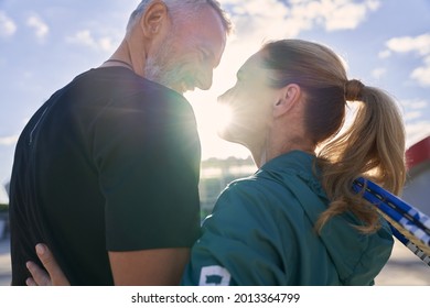 Happy Active Middle Aged Couple Looking At Each Other While Standing Together Outdoors, Ready For Morning Workout On Tennis Court