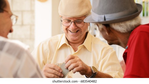 Happy Active Retired People, Old Hispanic Friends Having Fun, Seniors Playing Cards At Home.