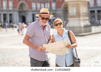 Happy Active Retired Tourist Couple Searching For Their Location In Plaza Mayor Madrid In Travel Around Europe Holidays Retirement Concept.