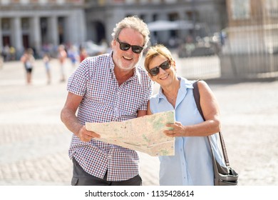 Happy Active Retired Tourist Couple Searching For Their Location In Plaza Mayor Madrid In Travel Around Europe Holidays Retirement Concept.