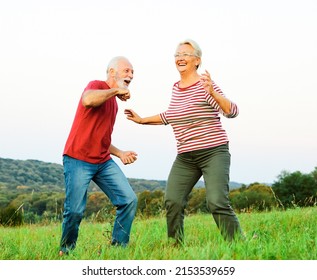 Happy Active Senior Couple Having Fun Dancing Outdoors