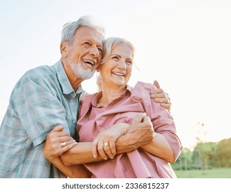 Happy active senior couple having fun talking and hugging in park outdoors - Powered by Shutterstock