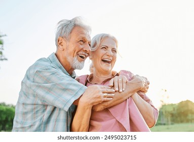 Happy active senior couple having fun talking and hugging in park outdoors - Powered by Shutterstock