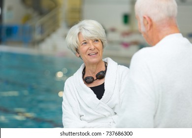 happy active senior couple talking while standing at poolside - Powered by Shutterstock