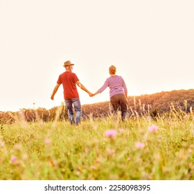 Happy active senior couple walking and holding hands outdoors - Powered by Shutterstock