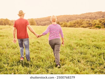 Happy active senior couple walking and holding hands outdoors - Powered by Shutterstock