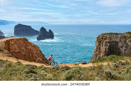 happy active senior woman cycling on the the rocky cliffs of the Vicentina coast of  Portugal near Sagres and Vila do Bispo  - Powered by Shutterstock