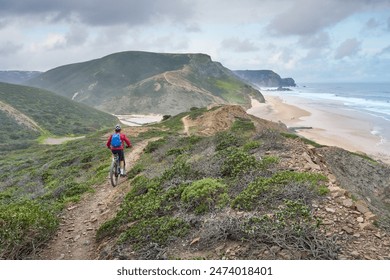 happy active senior woman cycling on the the rocky cliffs of the Vicentina coast of  Portugal near Sagres and Vila do Bispo  - Powered by Shutterstock