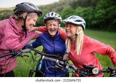 Happy Active Senior Women Friends Cycling Together Outdoors In Nature.