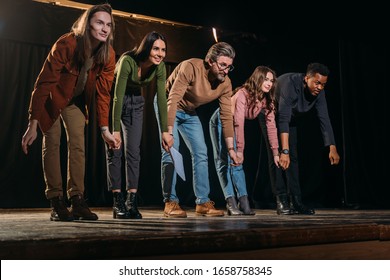 Happy Actors And Actresses Bowing On Stage