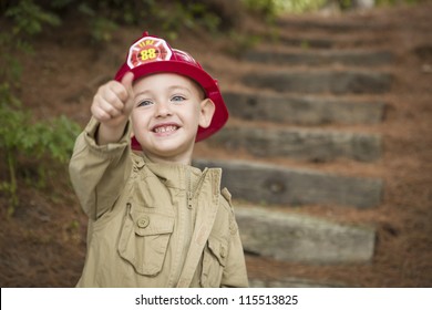 Happy Adorable Child Boy With Fireman Hat And Thumbs Up Playing Outside.