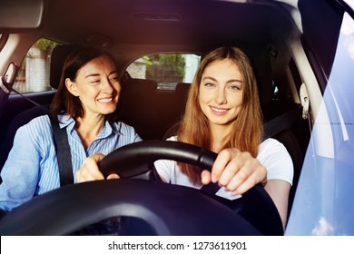 Happy adult daughter driving her mother in car