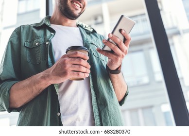 Happy adult guy is looking at screen of mobile phone - Powered by Shutterstock