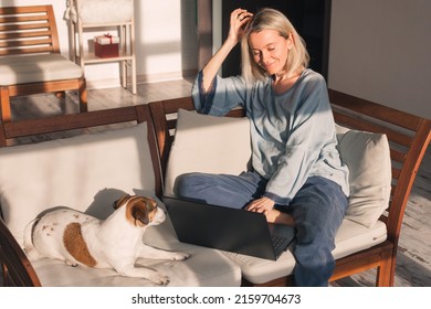 Happy Adult Lady Streaming Online Content On Laptop Sitting On The Sofa At Cozy Home, Middle Aged Woman Sitting On Couch With Dog