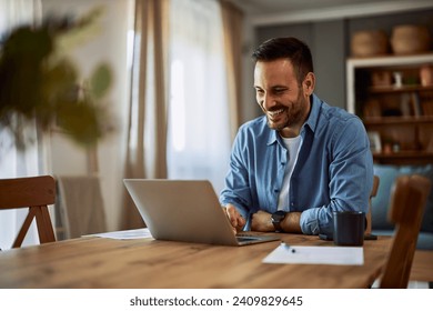 A happy adult male freelancer making a video call with a client to go through a new project using his laptop at a desk in a home office. - Powered by Shutterstock