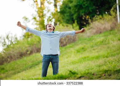 Happy Adult Man Celebreting With Open Arms Outside In Nature