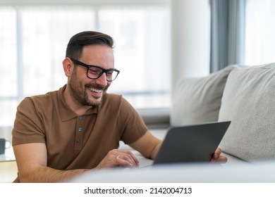 Happy Adult Man Checking Social Networks Or Make Purchase Online Or Checking His Bank Account On His Lap Top Satisfied With His Current Budget