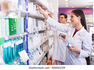 Happy Adult Pharmacist And Pharmacy Technician Posing In Drugstore