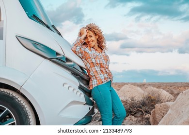 Happy Adult Woman Tourist Against Modern Camper Van Motorhome Smile And Look At The Camera. Female People Traveler Enjoy Destination And Vacation. Country Side And Blue Sky In Background