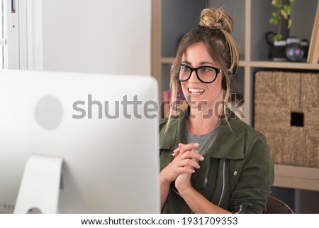 Happy adult young woman in video call conference at home in smart working free alternative office job lifestyle - pretty female people receive news on laptop computer and smile with joyful