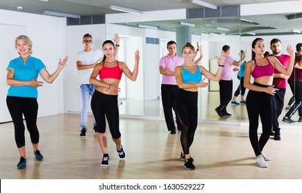 Happy Adults Dancing Salsa Or Bachata Together In Dance Studio