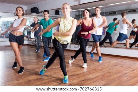 Happy adults having group fitness class in sport club