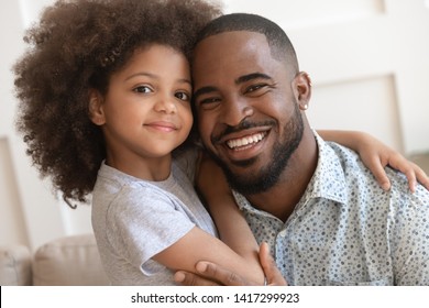 Happy affectionate african american family young daddy and small cute child daughter portrait, loving black dad and little mixed race kid girl bonding embrace looking at camera on fathers day concept - Shutterstock ID 1417299923