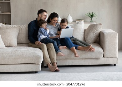 Happy Affectionate Loving Hispanic Family Couple And Small Adorable Children Boy Girl Using Computer, Shopping In Internet Store, Web Surfing, Watching Cartoons Online, Resting On Couch At Home.