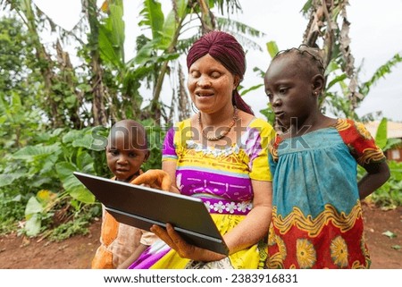 Happy African albino mother lectures her children on tablet. Education concept.