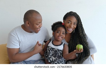 Happy African America Family Sitting On Sofa And Smile Together