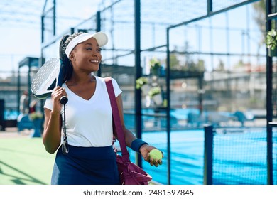 Happy African American athletic woman on paddle tennis court looking away. Copy space.  - Powered by Shutterstock