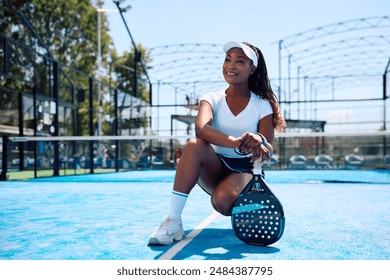 Happy African American athletic woman playing paddle tennis on outdoor court and looking away. Copy space. - Powered by Shutterstock