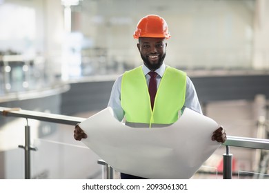 Happy African American Bearded Man In Workwear Holding Paper Drawing Template, Businessman Wearing Helmet Hard Hat And Protective Vest, Checking Construction Plan And Smiling, Copy Space