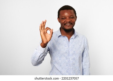 Happy African American Black Man With OK Gesture In Casual Bright Shirt Isolated On White Background. Smiling Adult Black Guy Portrait With Okay Gesture, Candid Excited Male Emotion