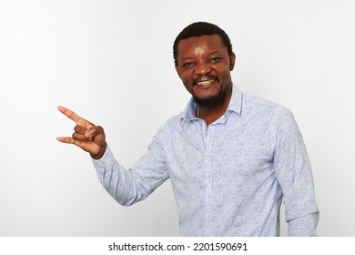 Happy African American Black Man With Sign Of Horns Gesture In Casual Bright Shirt Isolated On White Background. Smiling Adult Black Guy Portrait With Sign Of Horns, Candid Excited Male Emotion