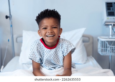 Happy african american boy patient sitting up in hospital bed, smiling with copy space. Hospital, medical and healthcare services. - Powered by Shutterstock