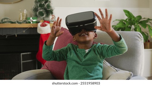 Happy african american boy wearing vr headset and having fun at christmas time. christmas, festivity and communication technology. - Powered by Shutterstock