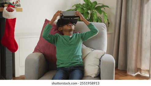 Happy african american boy wearing vr headset and having fun at christmas time. christmas, festivity and communication technology. - Powered by Shutterstock