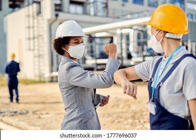 Happy African American Building Contractor And Construction Worker Greeting With Elbows During Coronavirus Epidemic. 