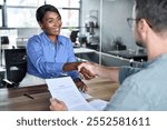 Happy African American business woman getting job handshaking bank manager at office meeting. Male hr hiring recruit at job interview, insurance agent, lawyer making contract deal with client at work.