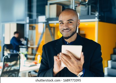 Happy african american businessman or designer or creative man with tablet in hands in modern office, business portrait - Shutterstock ID 1689773395