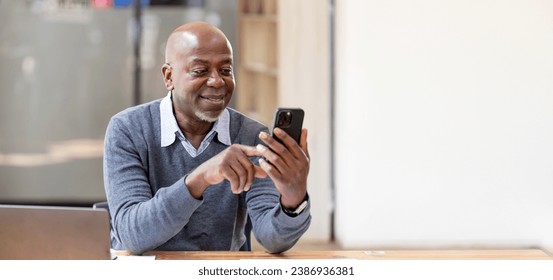 Happy african american businessman using phone mobile at workplace texting sms, smiling black man looking at smartphone browsing internet. - Powered by Shutterstock