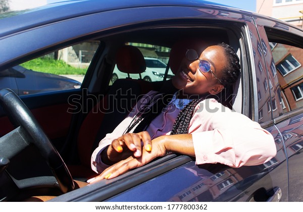 the happy\
African American in the car in\
sunglasses