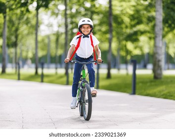 Happy african american child schoolboy in a helmet and with a briefcase rides a bike to school
 - Powered by Shutterstock