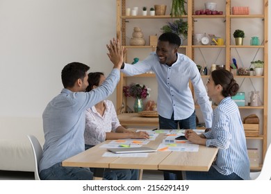 Happy African American coach giving motivating high five to intern for work, study achieve, well done project task. Boss, team leader and employees celebrating teamwork success, good sales result