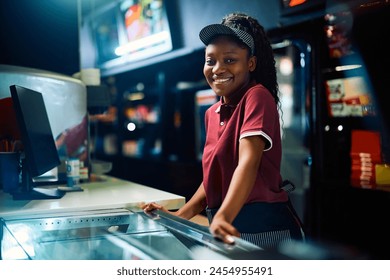 Happy African American concession stand worker in movie theater looking at camera. - Powered by Shutterstock