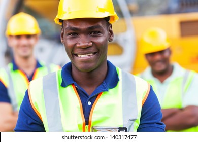 Happy African American Construction Worker In Front Of Colleagues