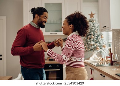 Happy African American couple celebrating Christmas and dancing at home. - Powered by Shutterstock