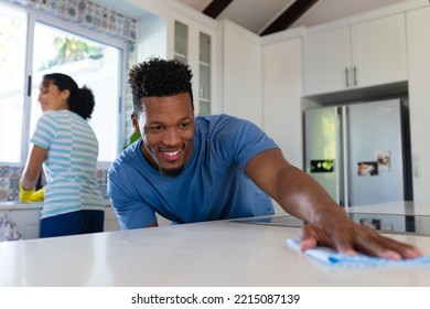 Happy african american couple cleaning countertop together in kitchen. Spending quality time at home together. - Powered by Shutterstock